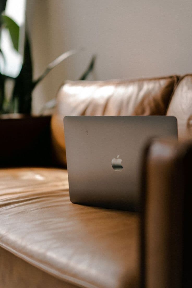 Poltrona clara com manta e xícara de café em composição aconchegante